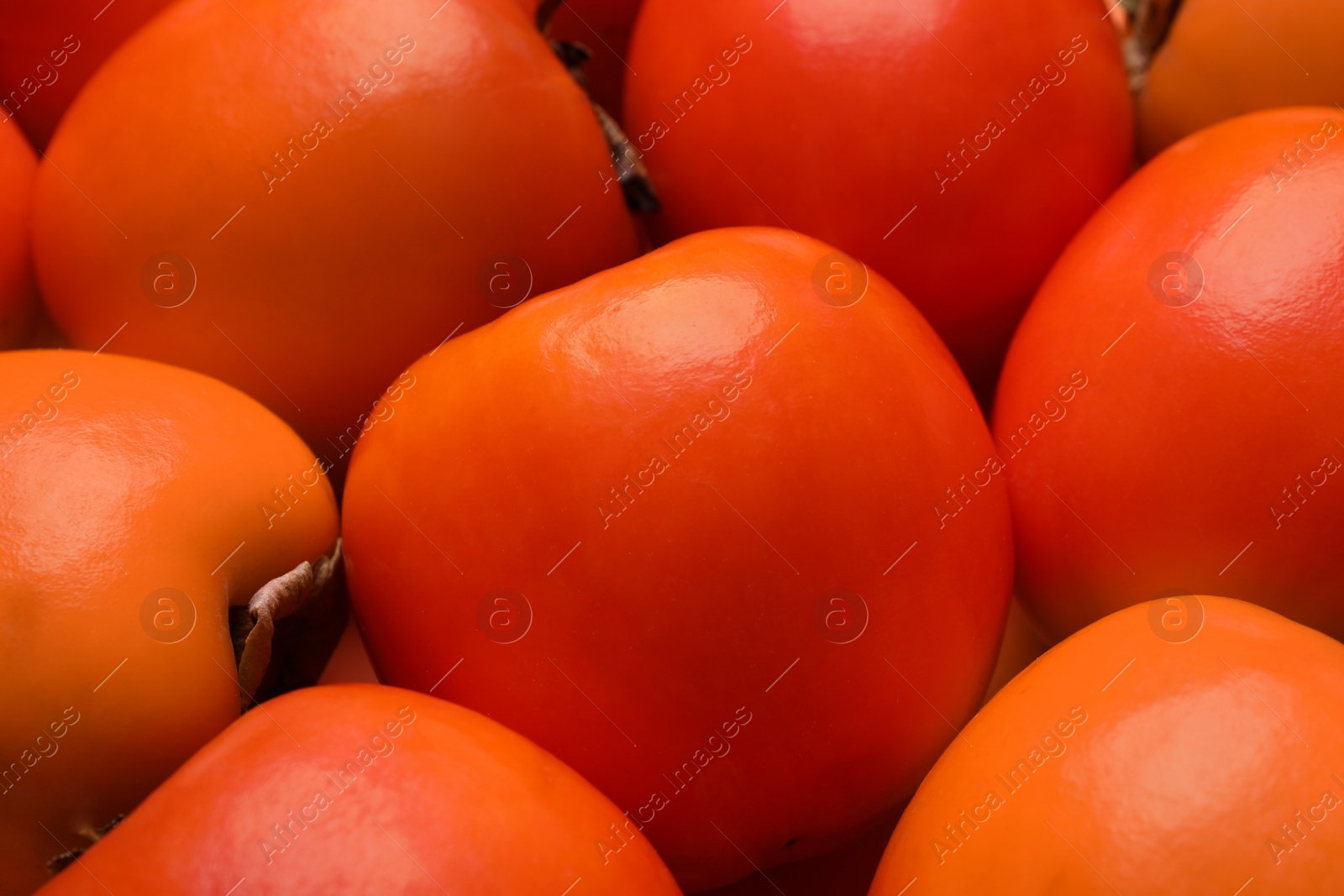 Photo of Delicious ripe juicy persimmons as background, closeup