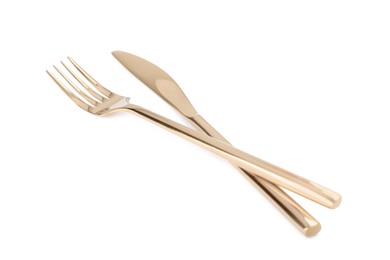 Photo of New shiny golden fork and knife on white background