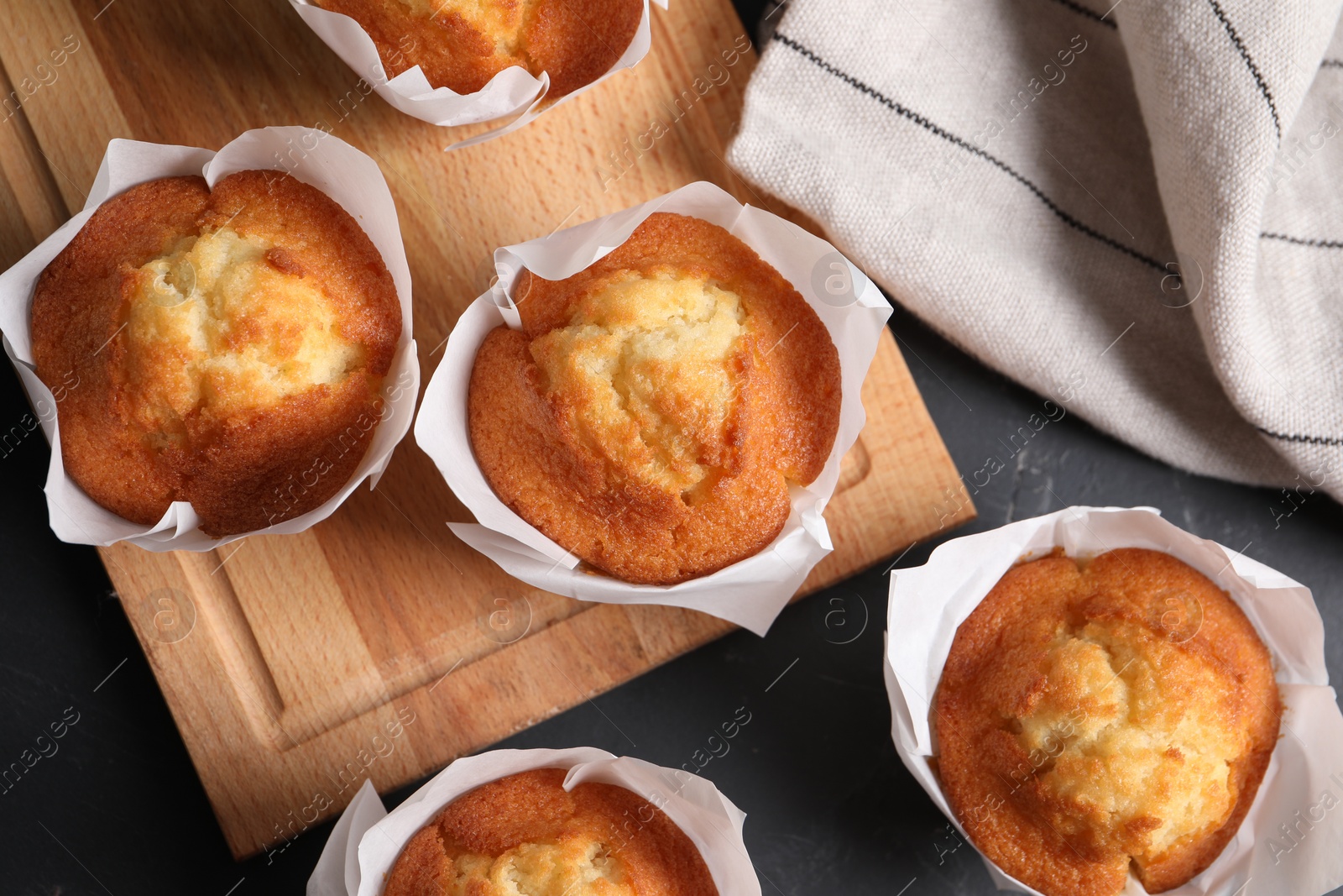 Photo of Tasty muffins on grey table, flat lay. Fresh pastry