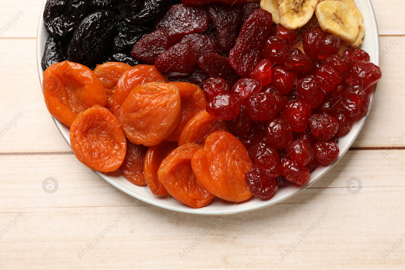 Photo of Delicious dried fruits on white wooden table, top view