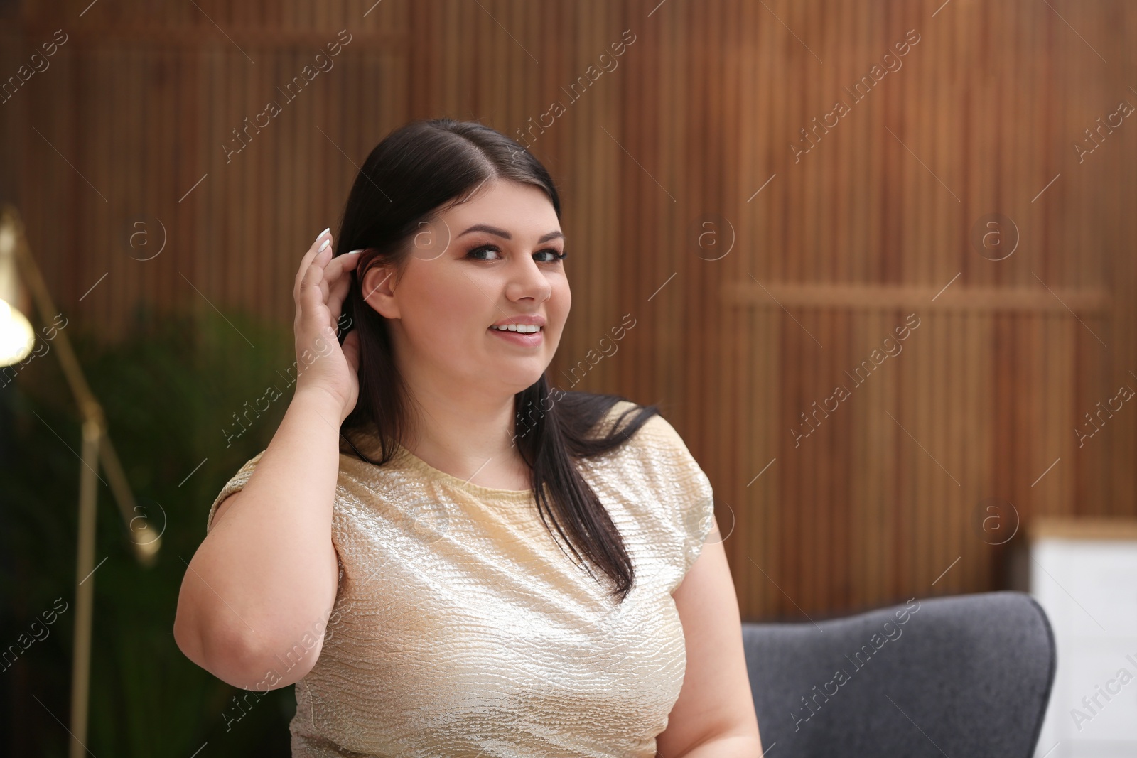 Photo of Beautiful overweight woman posing indoors. Plus size model