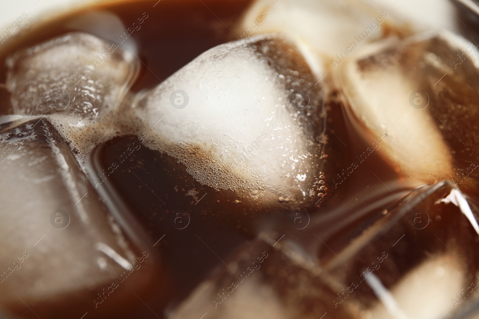 Photo of Tasty coffee drink with ice cubes, closeup