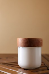 Photo of Jar of luxury cream on wooden table, space for text