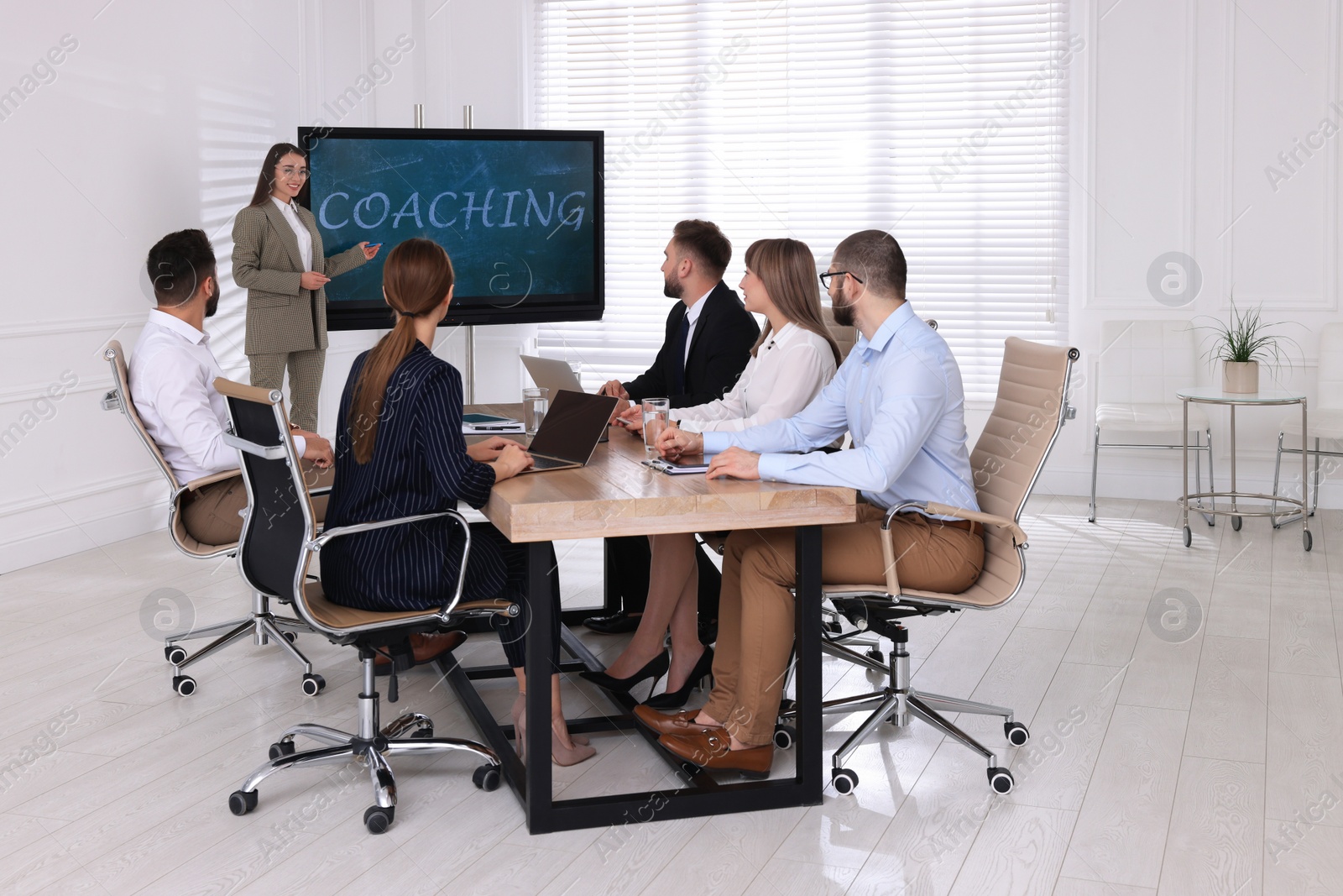 Photo of Business trainer using interactive board in meeting room during presentation