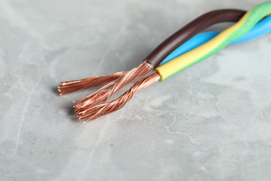 Colorful electrical wires on gray textured surface, closeup