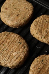 Photo of Delicious vegan cutlets cooking on electric grill, closeup