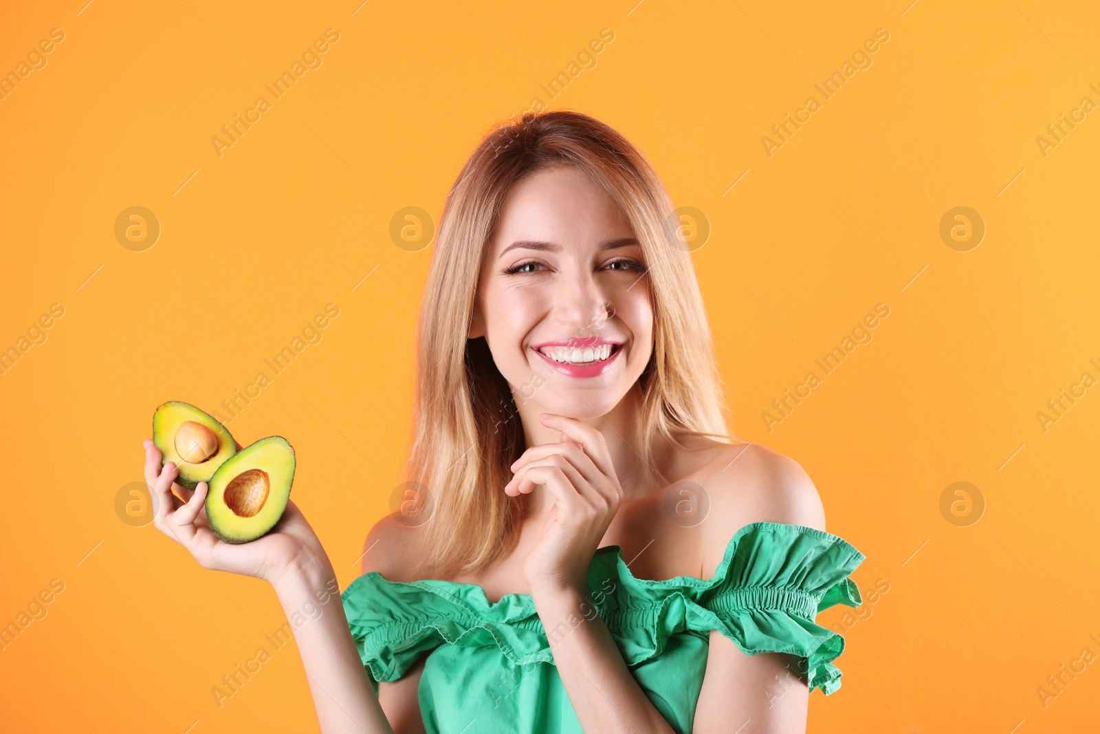 Photo of Portrait of young beautiful woman with ripe delicious avocado on color background