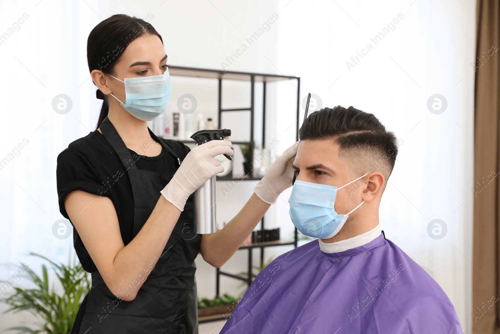 Photo of Professional stylist working with client in salon. Hairdressing services during Coronavirus quarantine