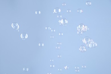 Photo of Beautiful transparent soap bubbles on light grey background