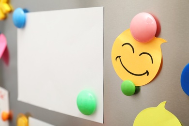 Photo of Sheets of paper and magnets on refrigerator door, closeup. Space for text