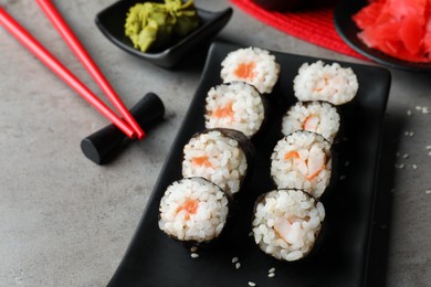 Photo of Tasty sushi rolls served on grey table