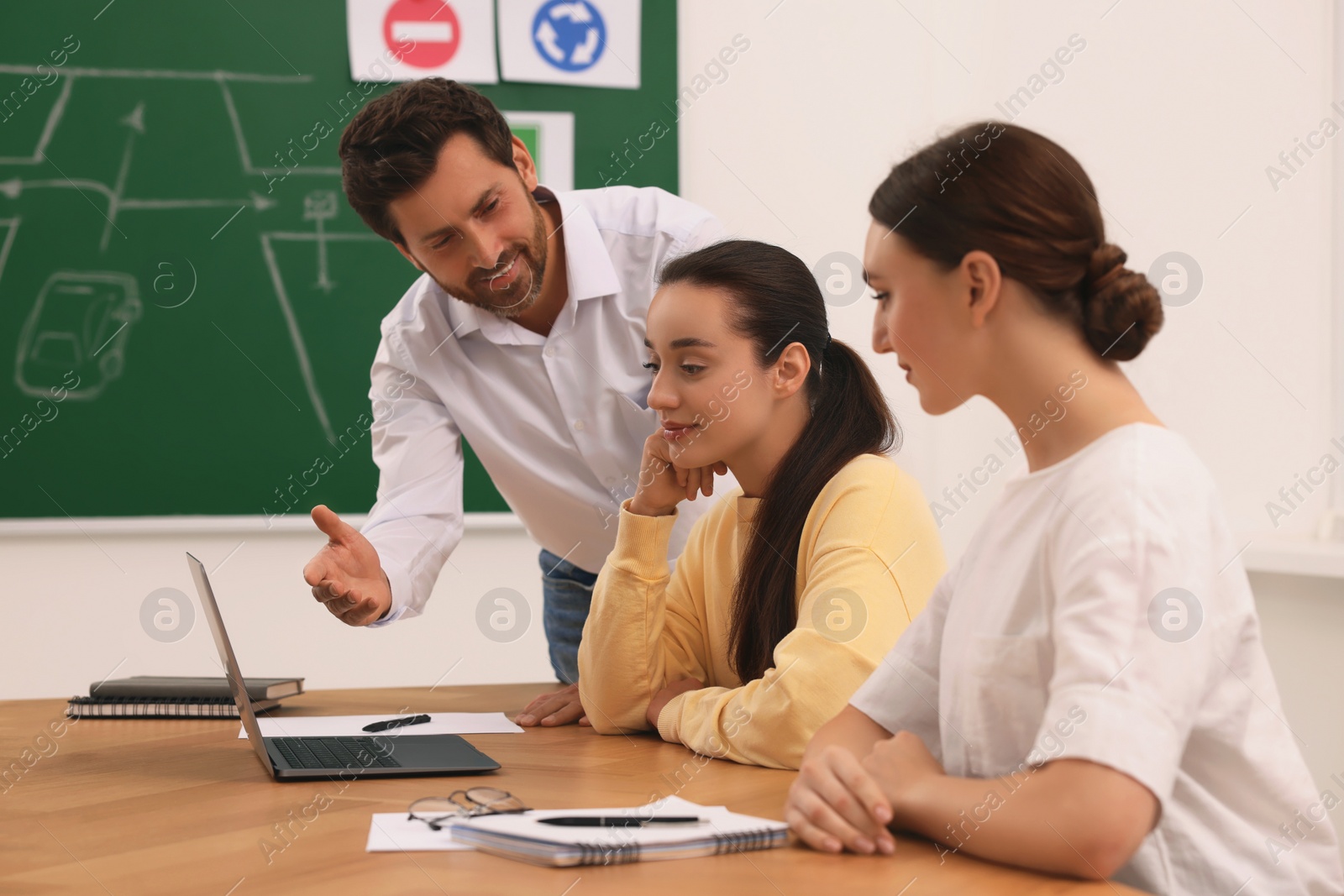 Photo of Happy teacher giving lesson in driving school