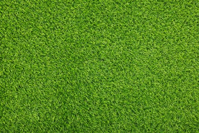 Green artificial grass as background, top view