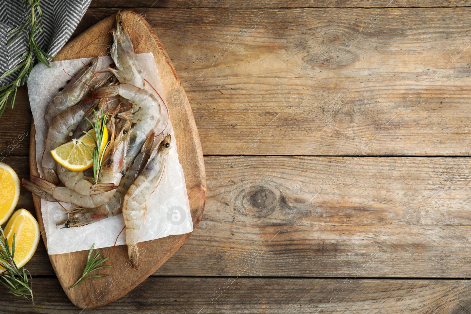 Photo of Flat lay composition with raw shrimps on wooden table. Space for text