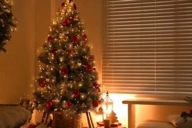 Beautiful decorated Christmas tree in festive room interior. Space for text