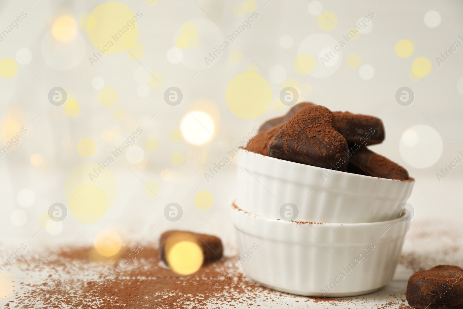 Photo of Delicious heart shaped chocolate candies on white table. Space for text
