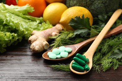 Photo of Dietary supplements. Spoons with different pills and food products on wooden table