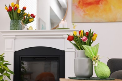 Easter decorations. Bouquet of tulips in vase and gift on table at home