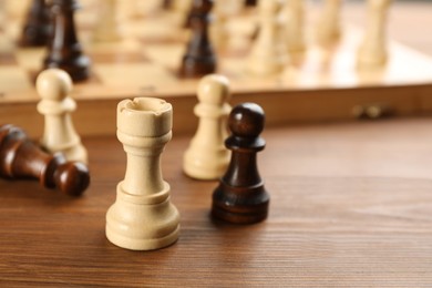 Photo of Closeup view of chess pieces on wooden table, space for text. Board game