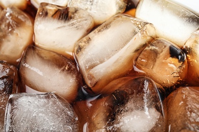 Closeup view of tasty refreshing cola with ice cubes as background