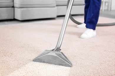 Image of Worker removing dirt from carpet indoors, closeup. Cleaning service 