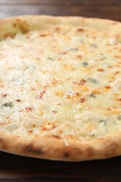 Photo of Delicious cheese pizza on wooden table, closeup