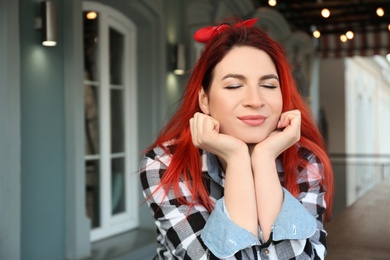 Photo of Young woman with bright dyed long hair outdoors