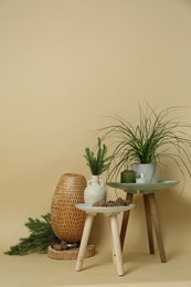 Photo of Decorative tables with candles and plants on beige background