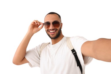 Smiling young man in sunglasses taking selfie on white background