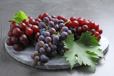 Fresh ripe juicy grapes on grey table