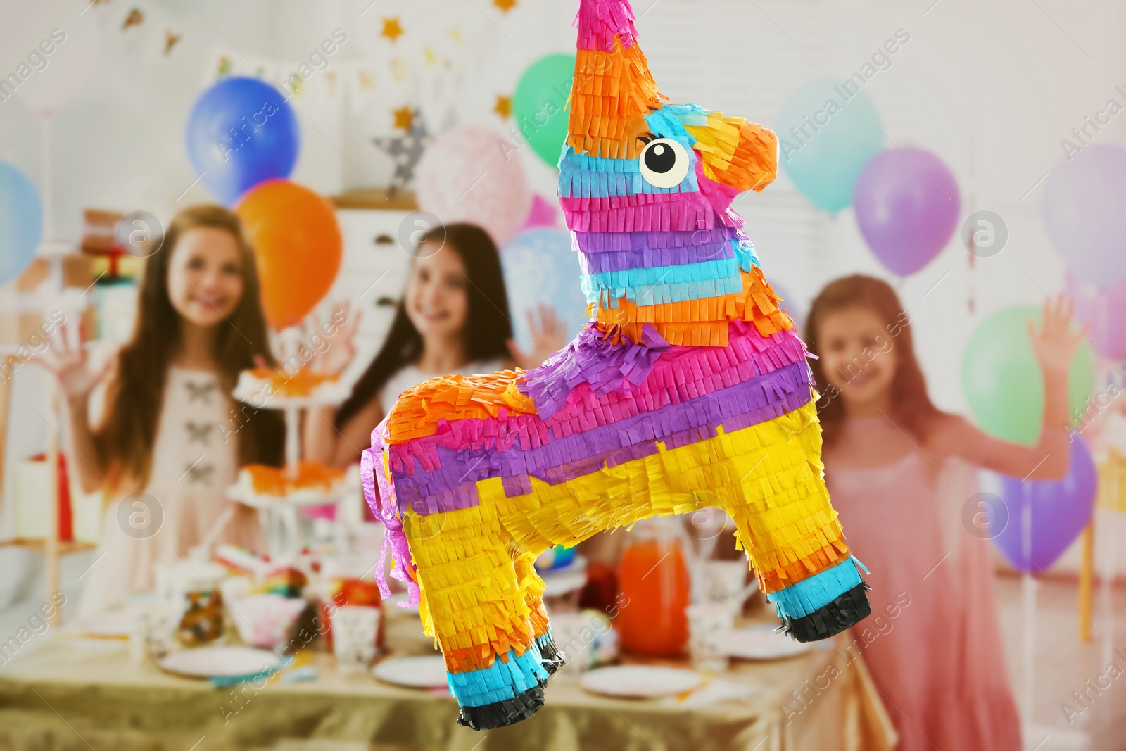 Image of Bright festive pinata hanging indoors at birthday party