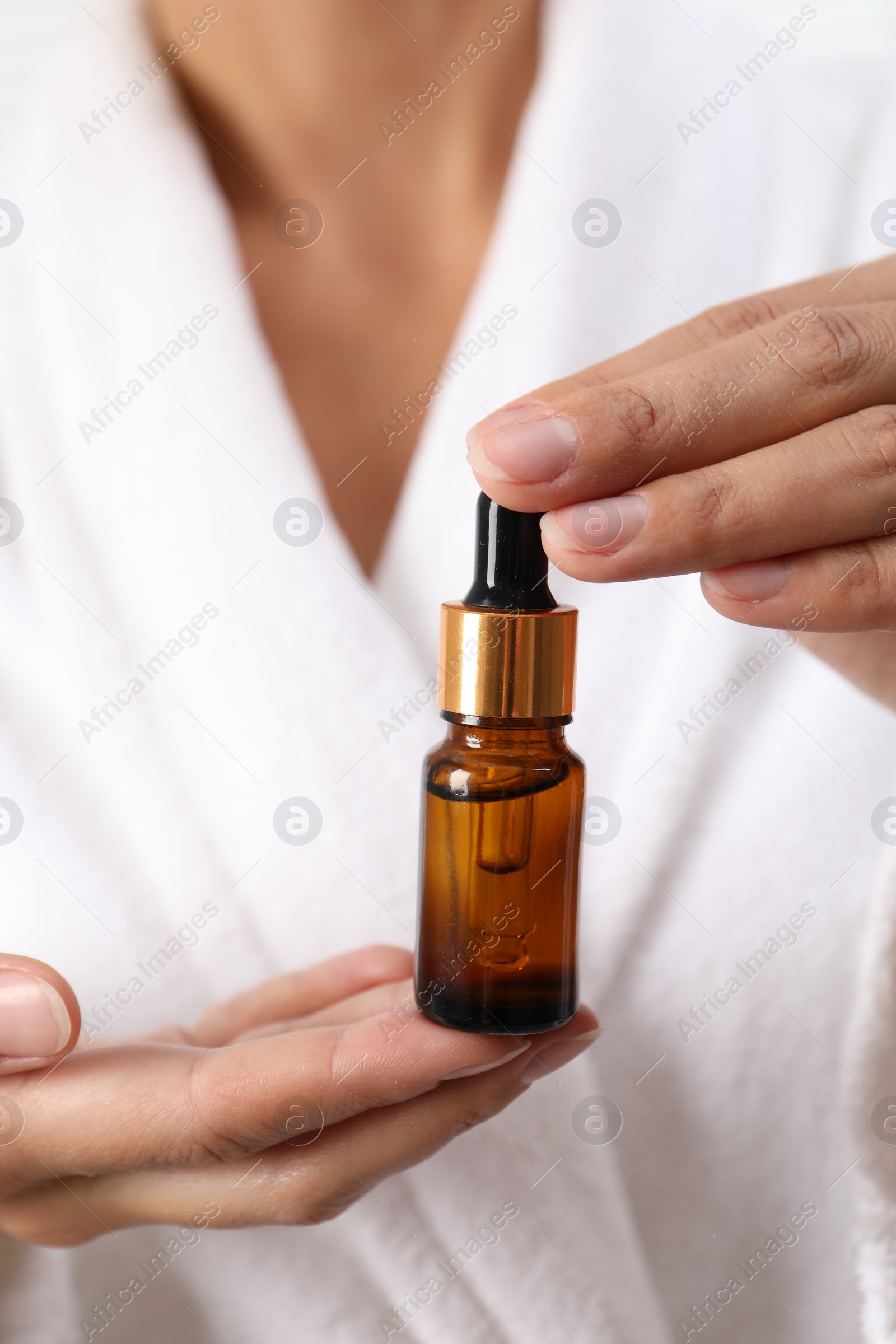 Photo of Woman with bottle of cosmetic serum, closeup