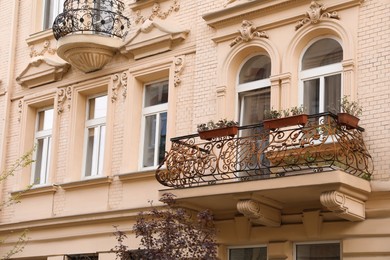 Exterior of beautiful beige building with balconies and stucco decor