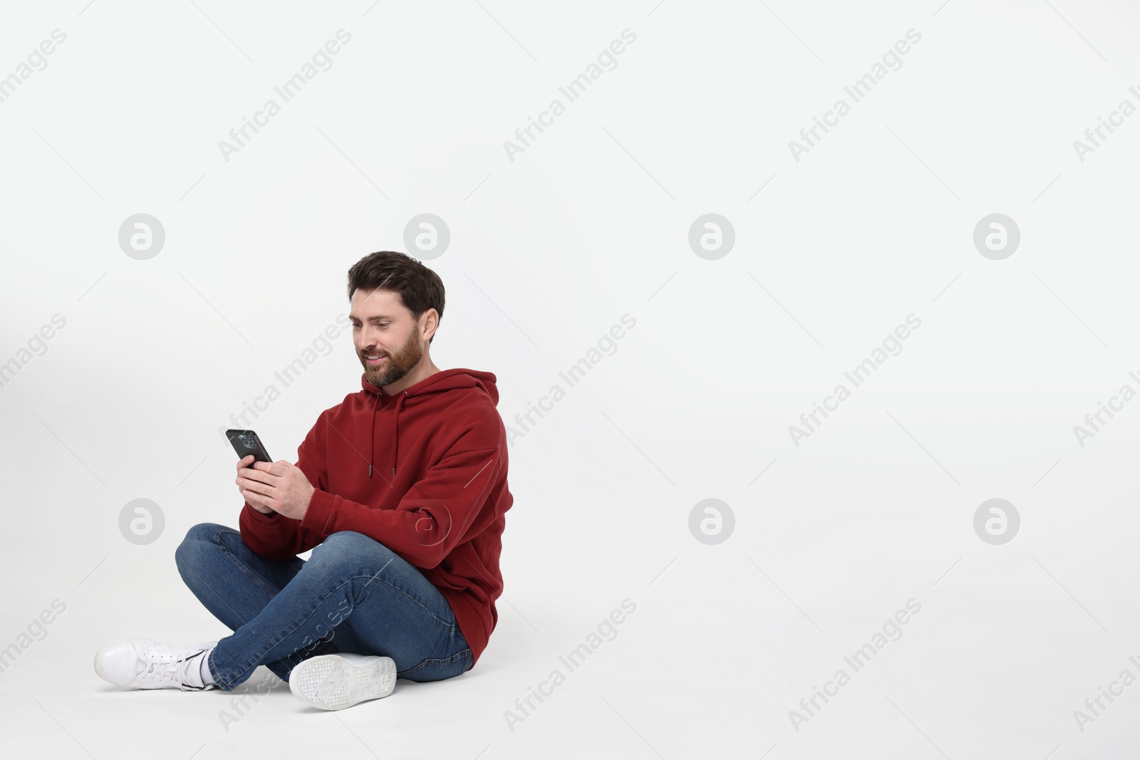 Photo of Happy man with smartphone on white background. Space for text