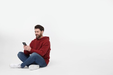 Photo of Happy man with smartphone on white background. Space for text