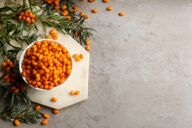 Photo of Fresh ripe sea buckthorn on grey table, flat lay. Space for text