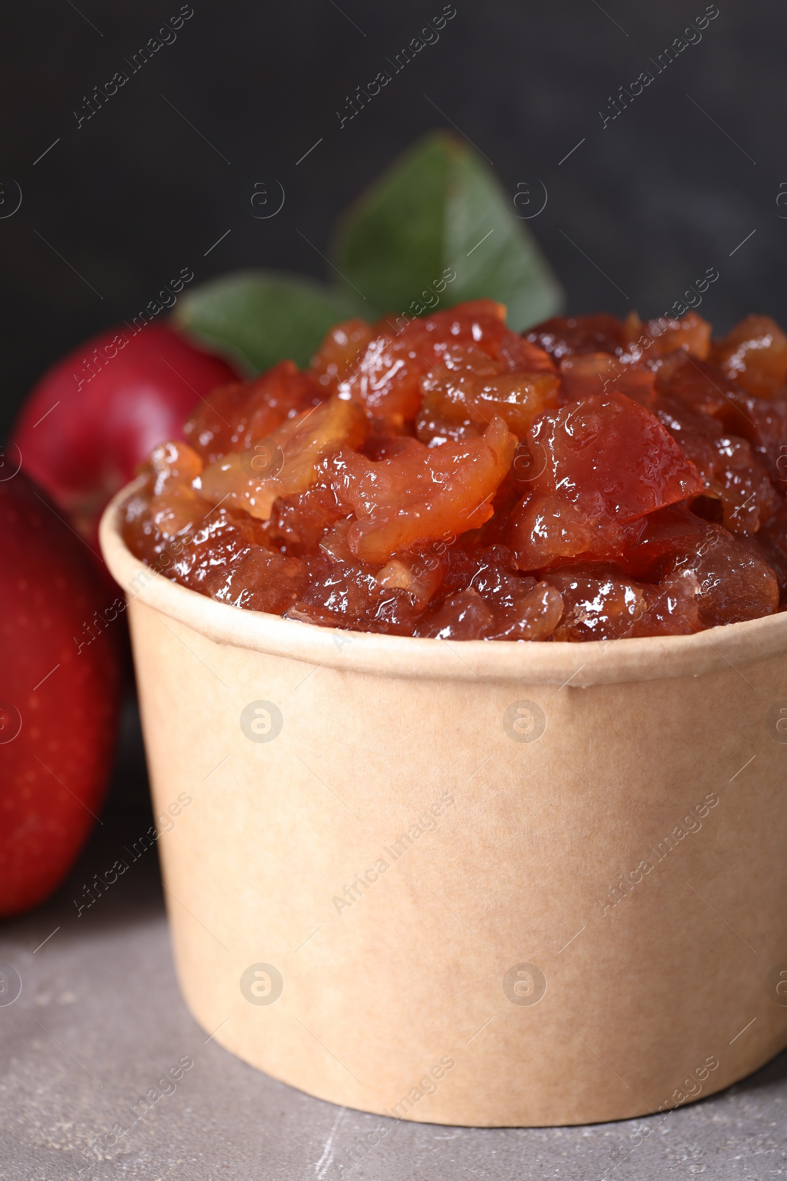 Photo of Delicious apple jam and fresh fruits on grey table, closeup