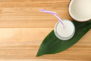 Flat lay composition with glass of coconut water on wooden background. Space for text