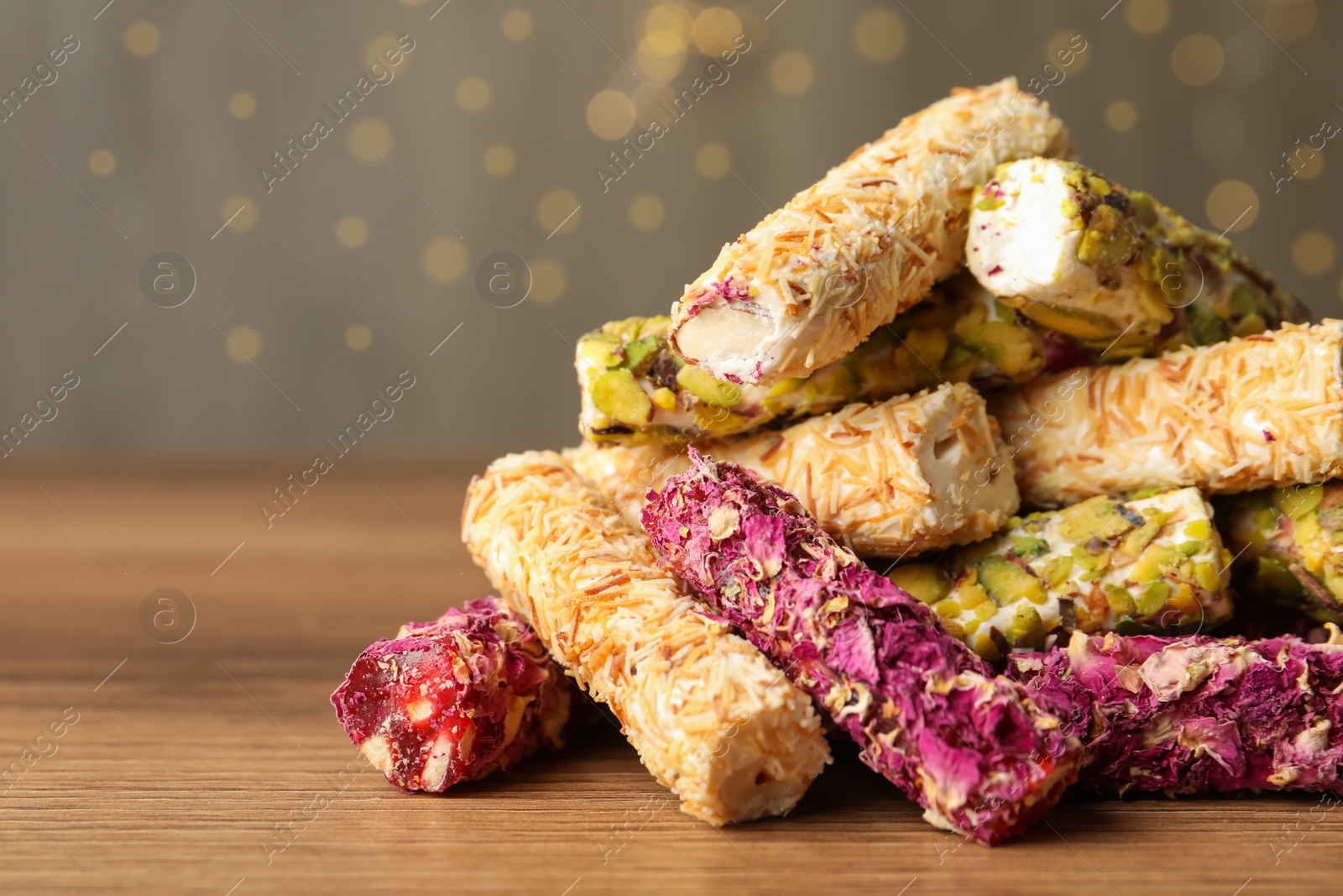 Photo of Turkish delight dessert on wooden table, closeup. Space for text