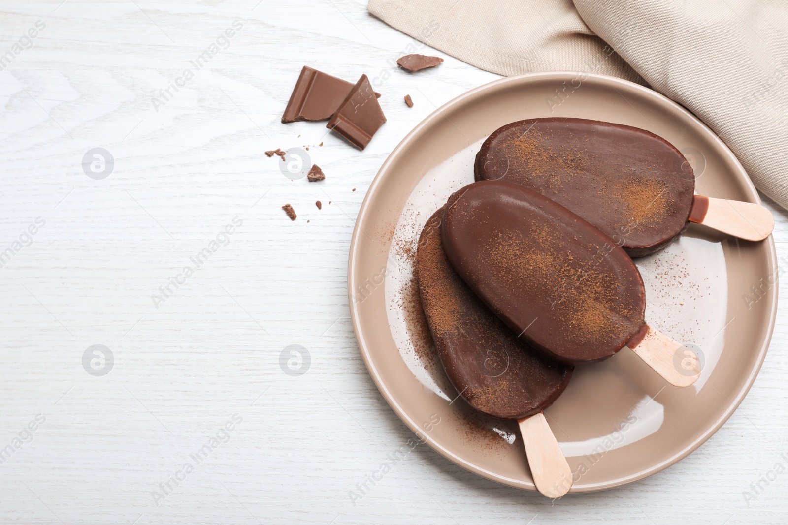 Photo of Delicious glazed ice cream bars and chocolate on white wooden table, flat lay. Space for text