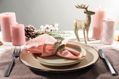 Photo of Stylish table setting with pink fabric napkin, beautiful decorative ring and festive decor on white background