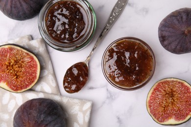 Photo of Tasty sweet fig jam and fruits on white marble table, flat lay