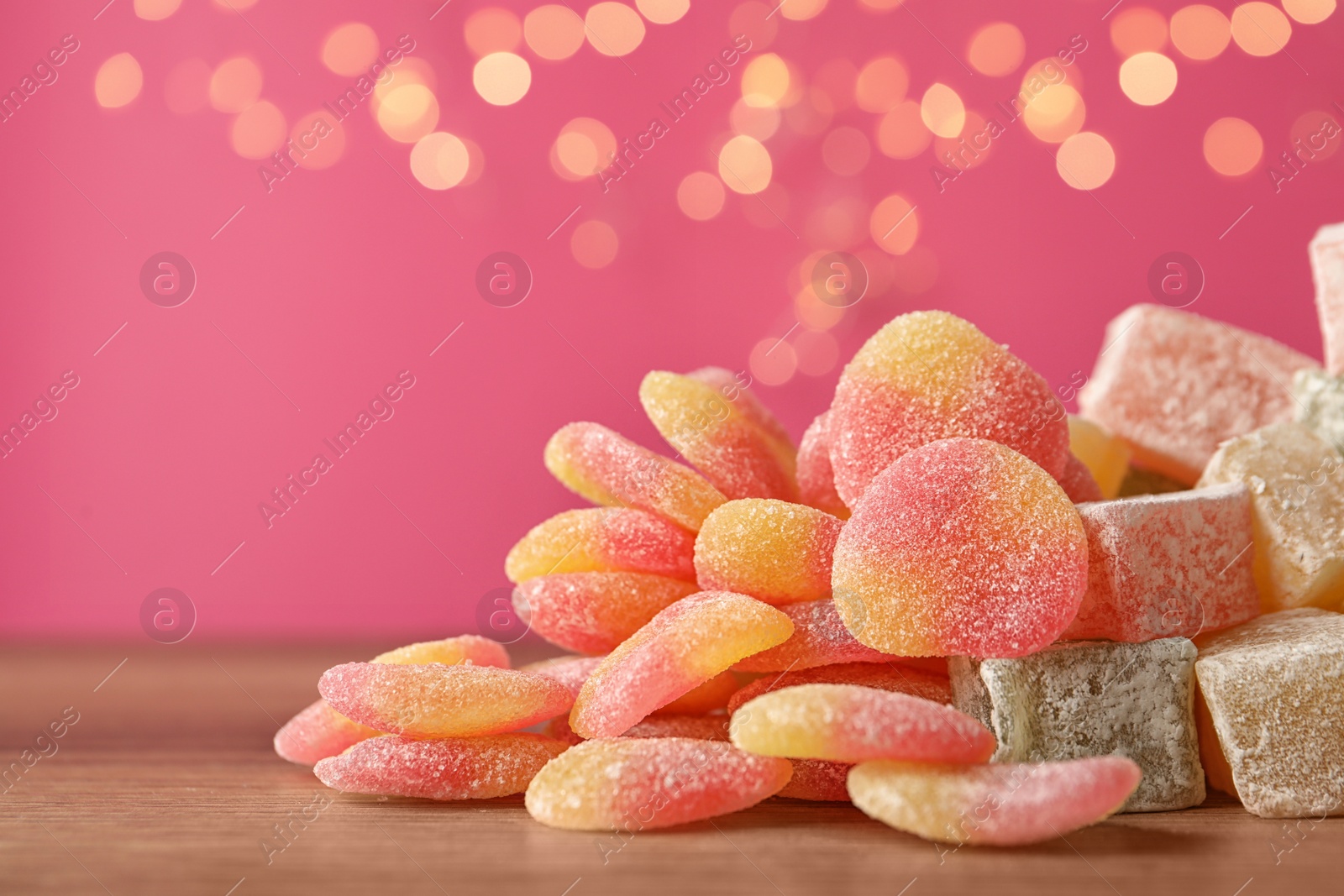 Photo of Pile of tasty sweets on wooden table, closeup. Space for text