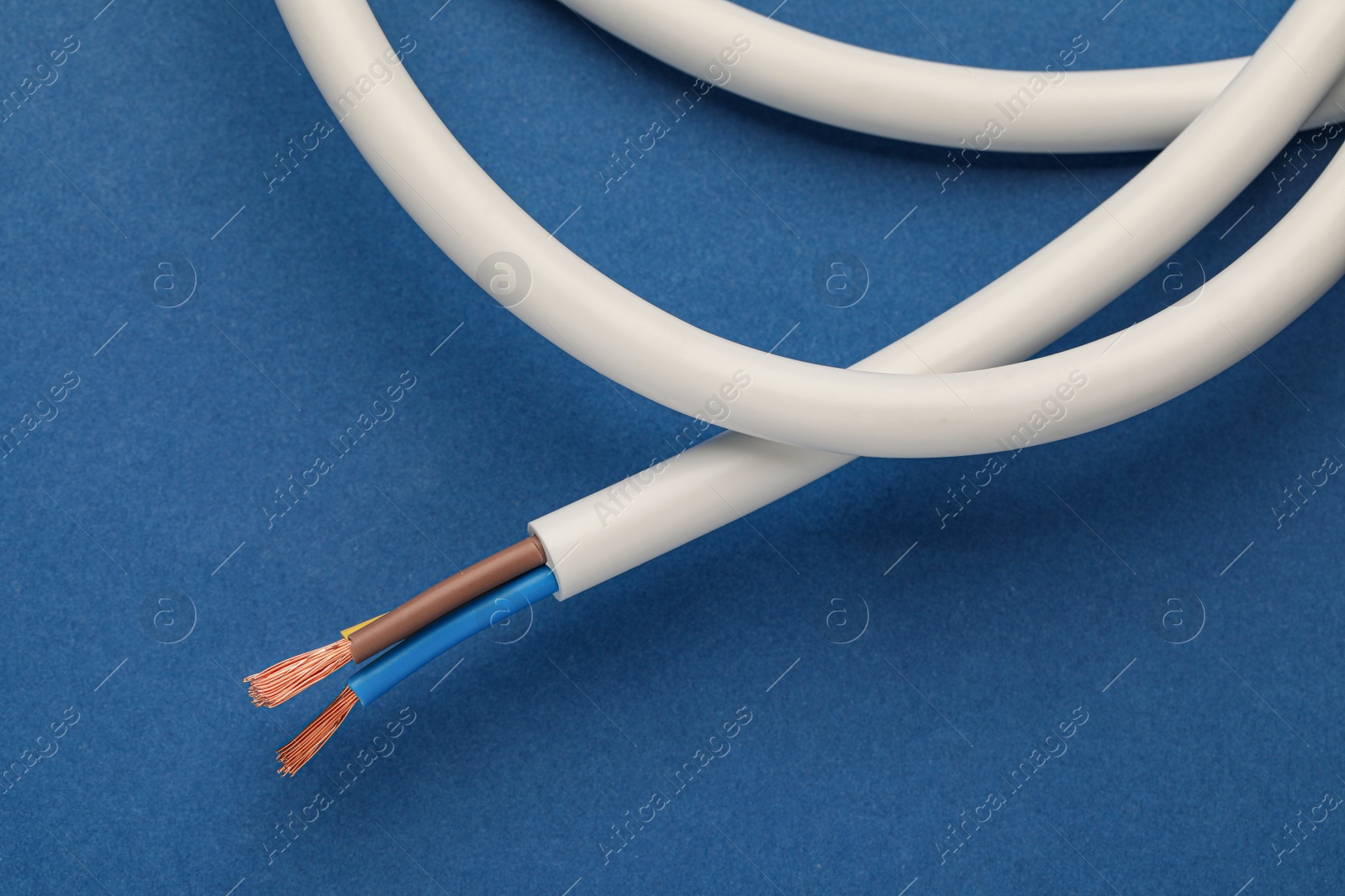 Photo of Electrical wires on blue background, closeup view