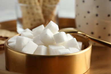 Photo of Refined sugar cubes in bowl on table, closeup