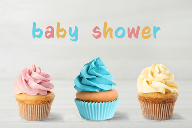 Image of Delicious cupcakes for baby shower party on light background