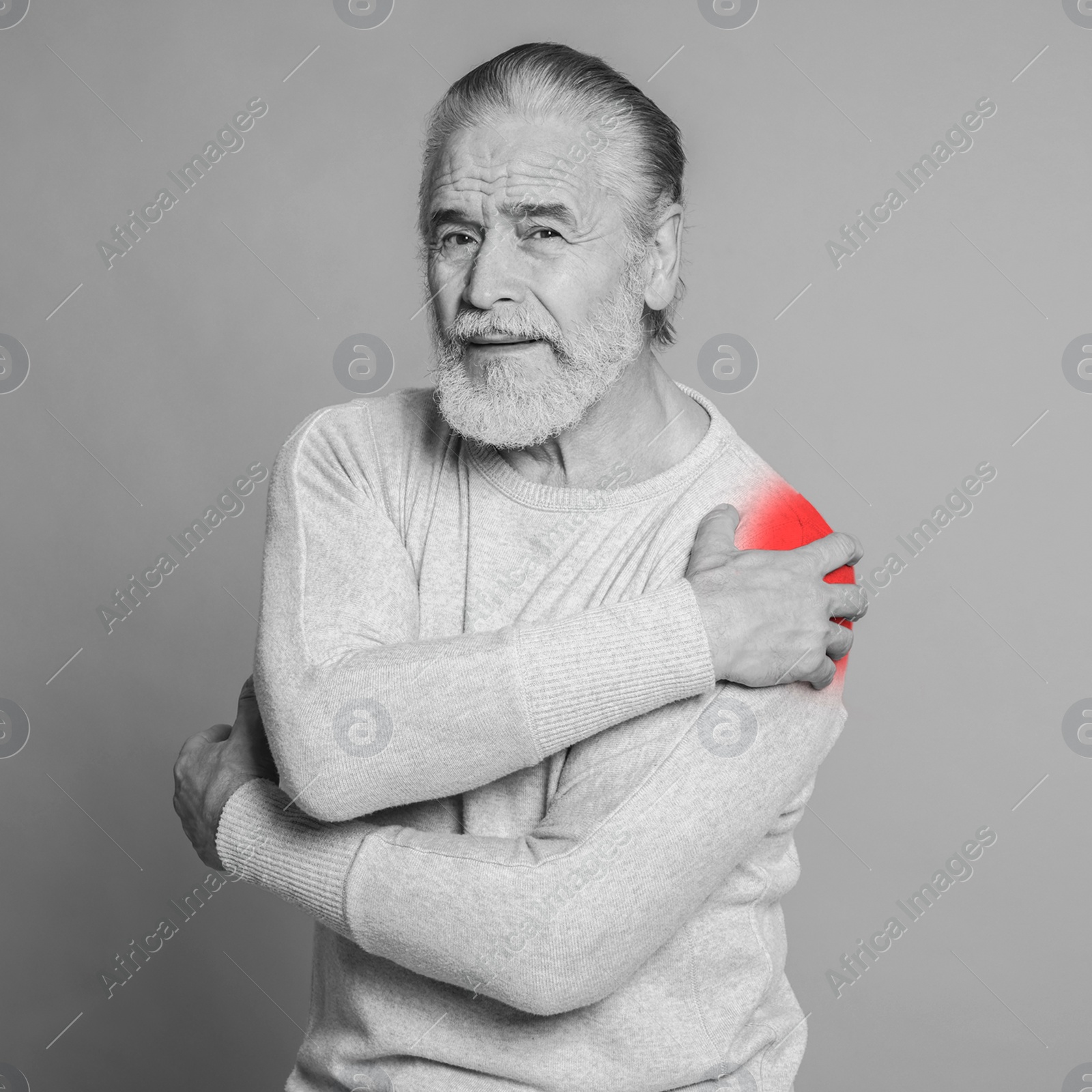 Image of Senior man suffering from rheumatism on light background. Black and white effect with red accent in painful area