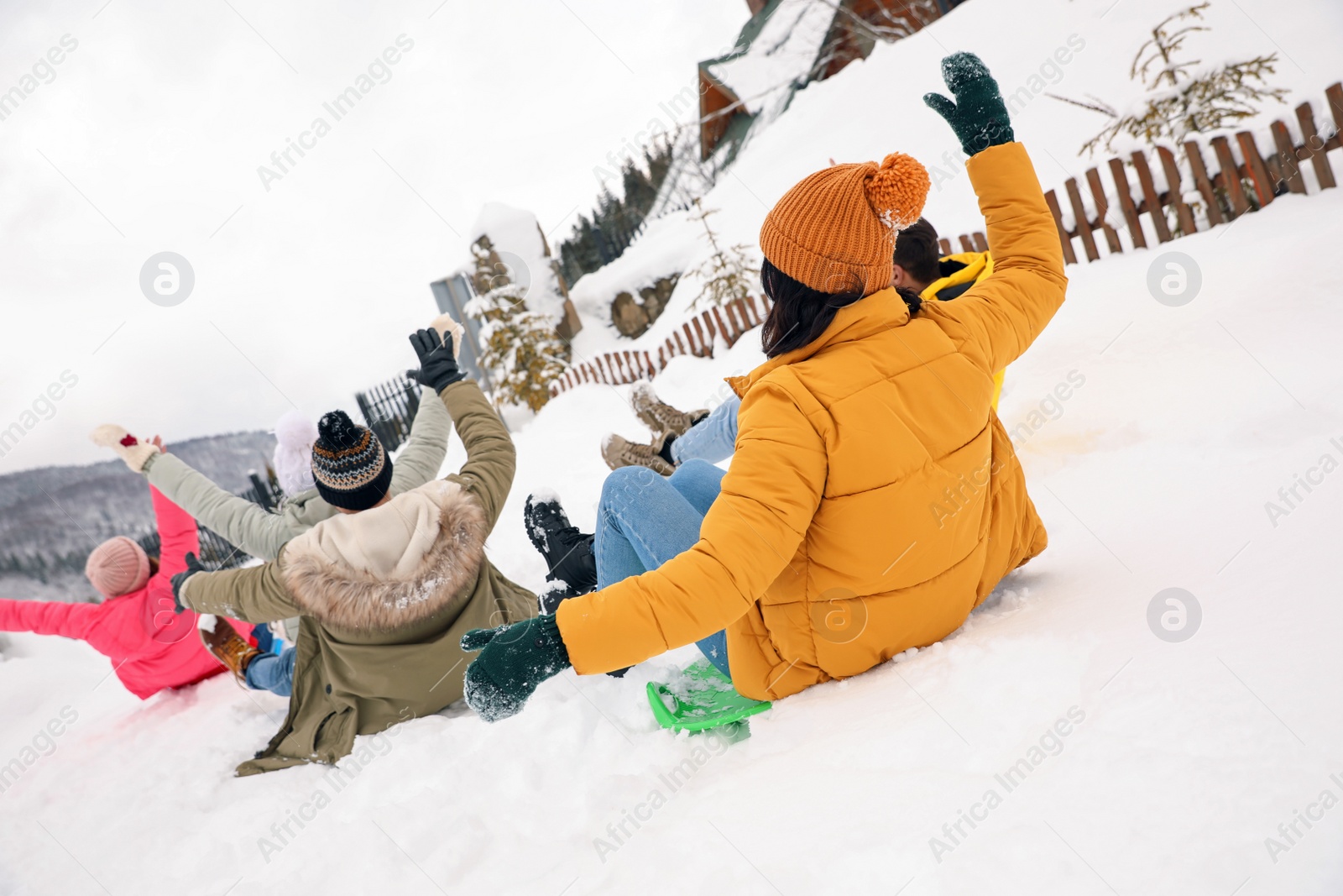 Photo of Group of friends having fun and sledding on snow. Winter vacation