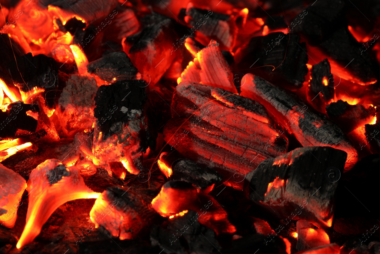 Photo of Pieces of hot smoldering coal as background, closeup