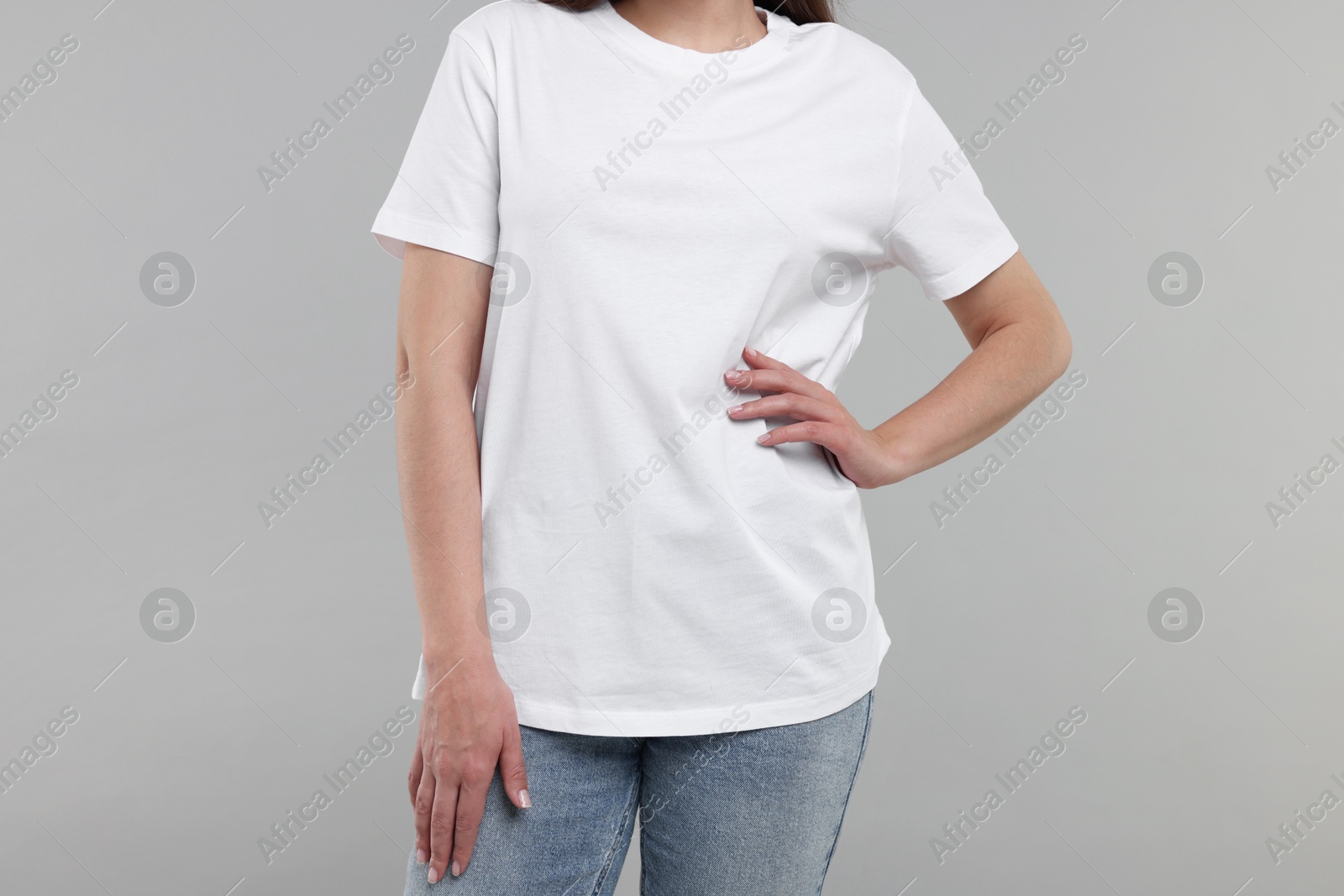 Photo of Woman in white t-shirt on grey background, closeup